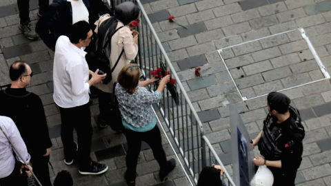 Cumartesi Anneleri polis barikatının önünde karanfil tutuyor. 