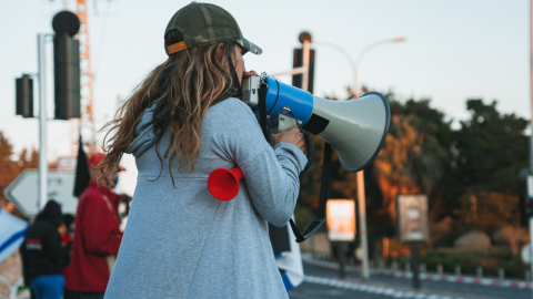 A woman protestor making a public statement with a speaker 