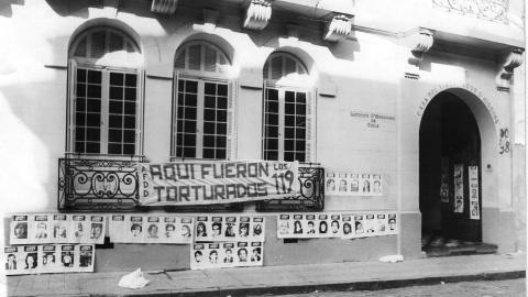 this photograph from 1980 shows a banner reading “Aquí fueron torturados los 119 / 119 people were tortured here” hung on the building that was used as O’Higgins Institute for Military Research at the time.